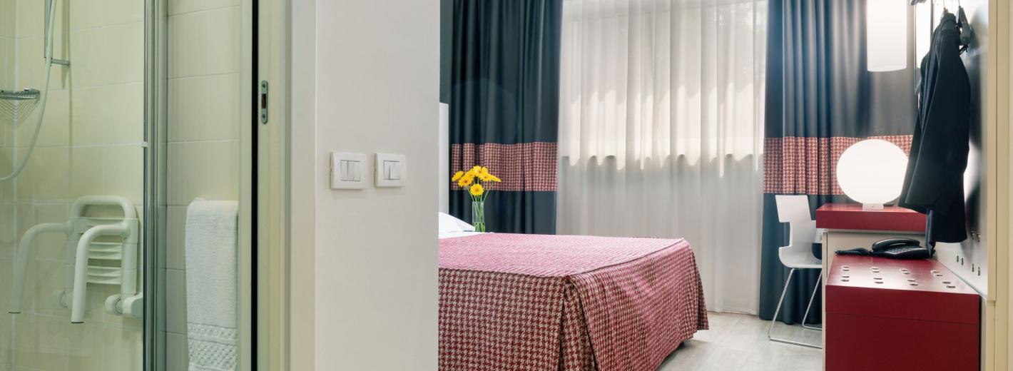 Habitación acogedora con cama doble y baño moderno, ambiente cálido y relajante.